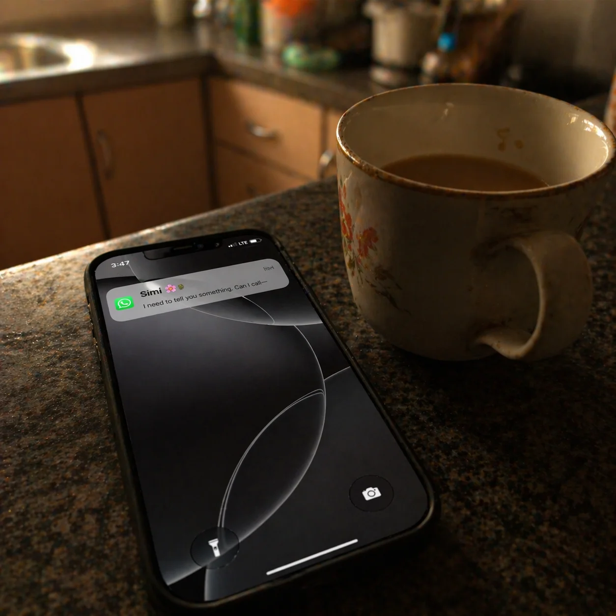 Phone lying on a kitchen counter, WhatsApp notification from Simi, tea going cold beside it